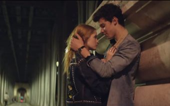 A young couple stands close together at night under a bridge, gazing into each other’s eyes—radiating the electric chemistry found in Shawn Mendes’ Theres Nothing Holding Me Back. The girl’s studded black jacket adds an edgy touch to their intimate moment.