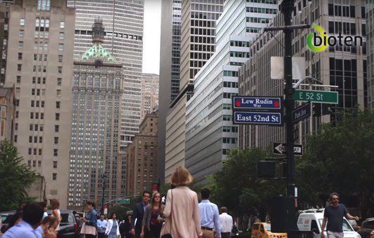 A busy city street scene with people walking, tall buildings in the background, and street signs for E 52nd St and East 52nd St. The Bioten logo appears in the upper right corner, highlighting a commercial vibe with a touch of detox-inspired energy.