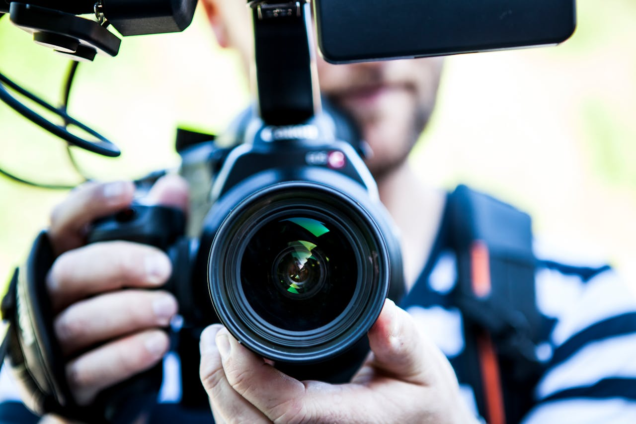 A man holding a camera, ready to capture moments and explore the art of filmmaking.