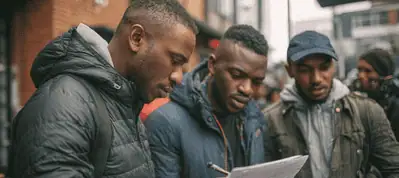 Three men wearing jackets stand outside, closely examining and discussing a sheet of paper. The background reveals an urban street scene in Johannesburg, hinting at a filming location with blurred buildings and people.