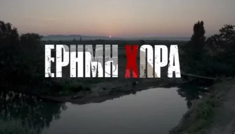 A scenic landscape at sunset features trees, a river, and distant mountains. Overlaid in bold white text with a red X, the stylized blocky font gives this image a dramatic, Wilder trailer-inspired look.